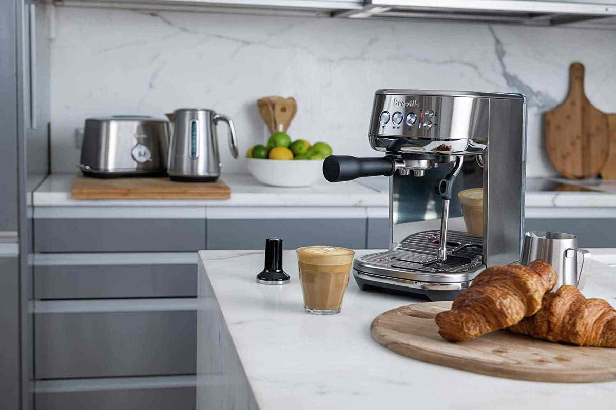 Breville Bambino Plus espresso machine in brushed stainless steel with compact design and automatic frothing features